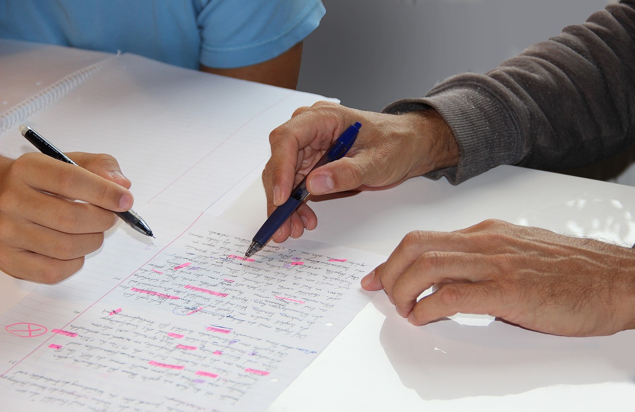 study-5645247_1280 Decorative shot of Hands holding pens over document