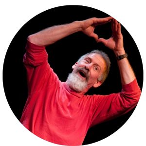 Tom Pease in Red Shirt making a Triangle with hands while singing